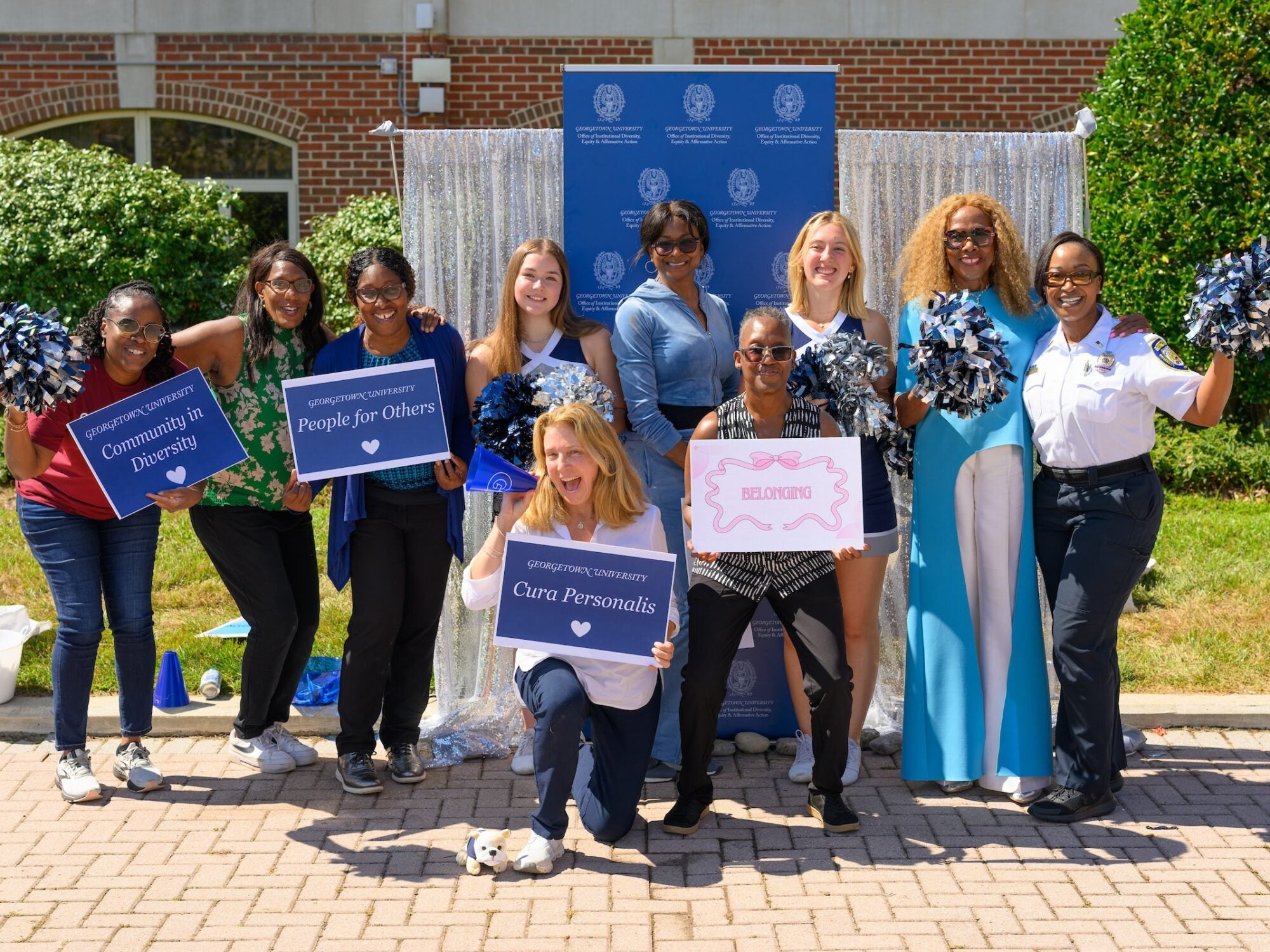 students posing with alumni smiling. they have signs that say community in diversity